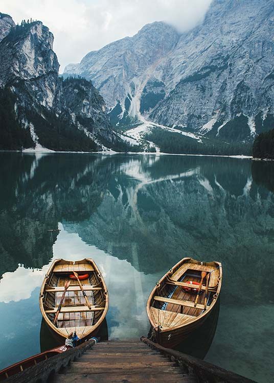  – Fotografie, die zwei Boote in einem See zeigt, im Hintergrund nebelige Berge