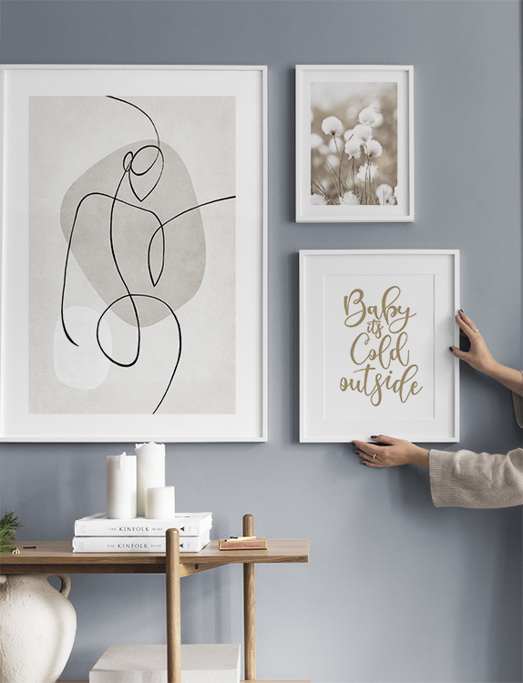 Eine ruhige Bilderwand mit Zitaten, Fotografien und Illustrationen in Naturfarben für den Flur
